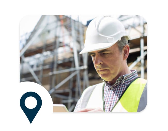 A contractor on a job site uses ConstructConnect’s software on a tablet to find projects, check bids, and connect with subs.