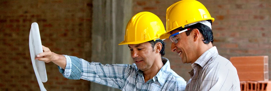 Contractors at a worksite looking at a blueprint